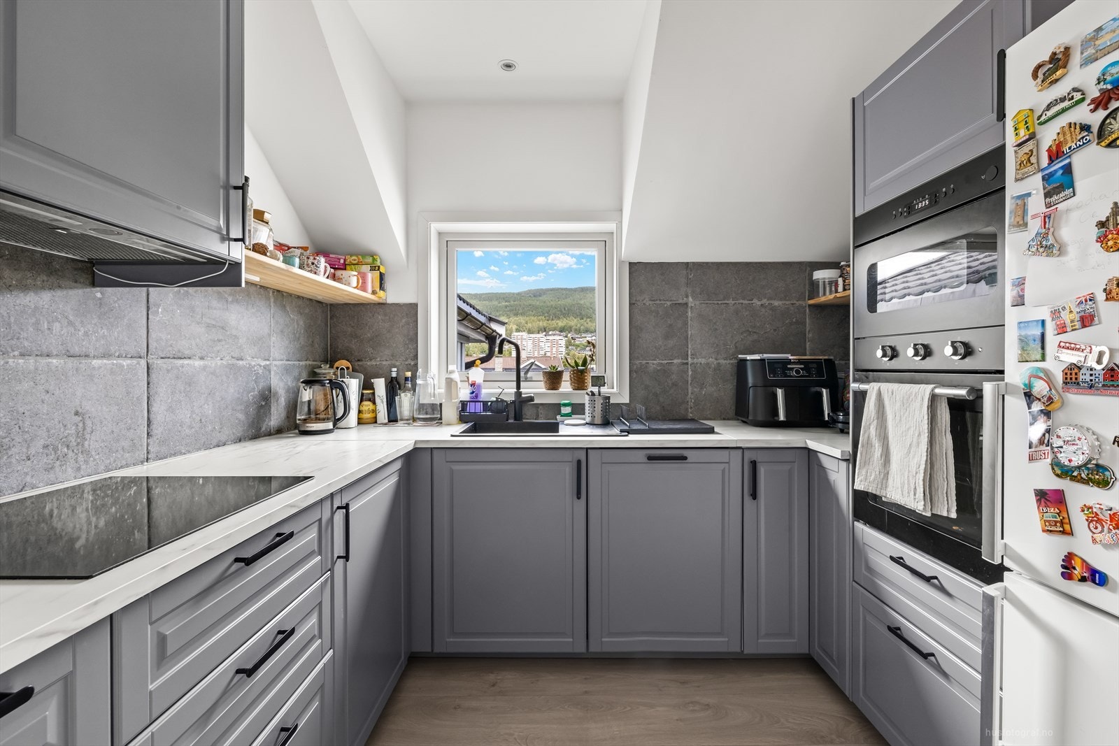 Nyoppusset kjøkken med pen innredning og rikelig skap- og benkeplass. Galleribilde