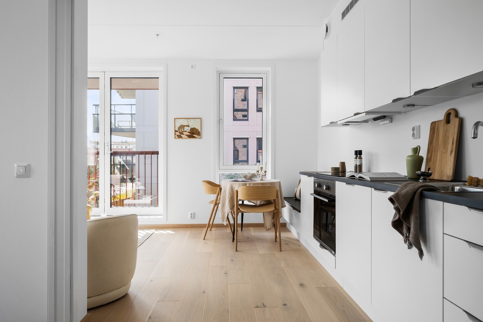 Kjøkkenet er levert fra Norema med klassiske hvite fronter, sort laminat benkeplate og spotter under overskap. Galleribilde