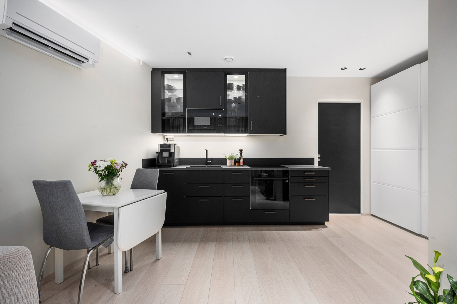 Kjøkken i hybel med spiseplass og garderobeløsning Galleribilde