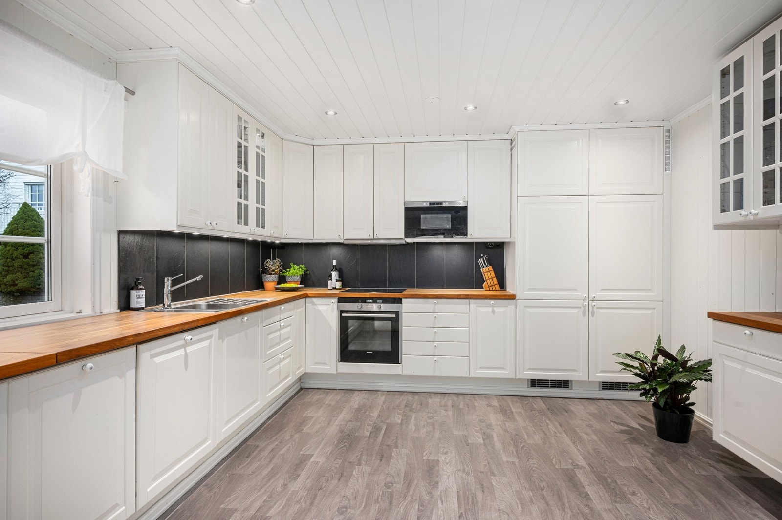 Romslig kjøkken med benkeplass og godt med skap og skuffer. Alle hvitevarer integrert. Galleribilde