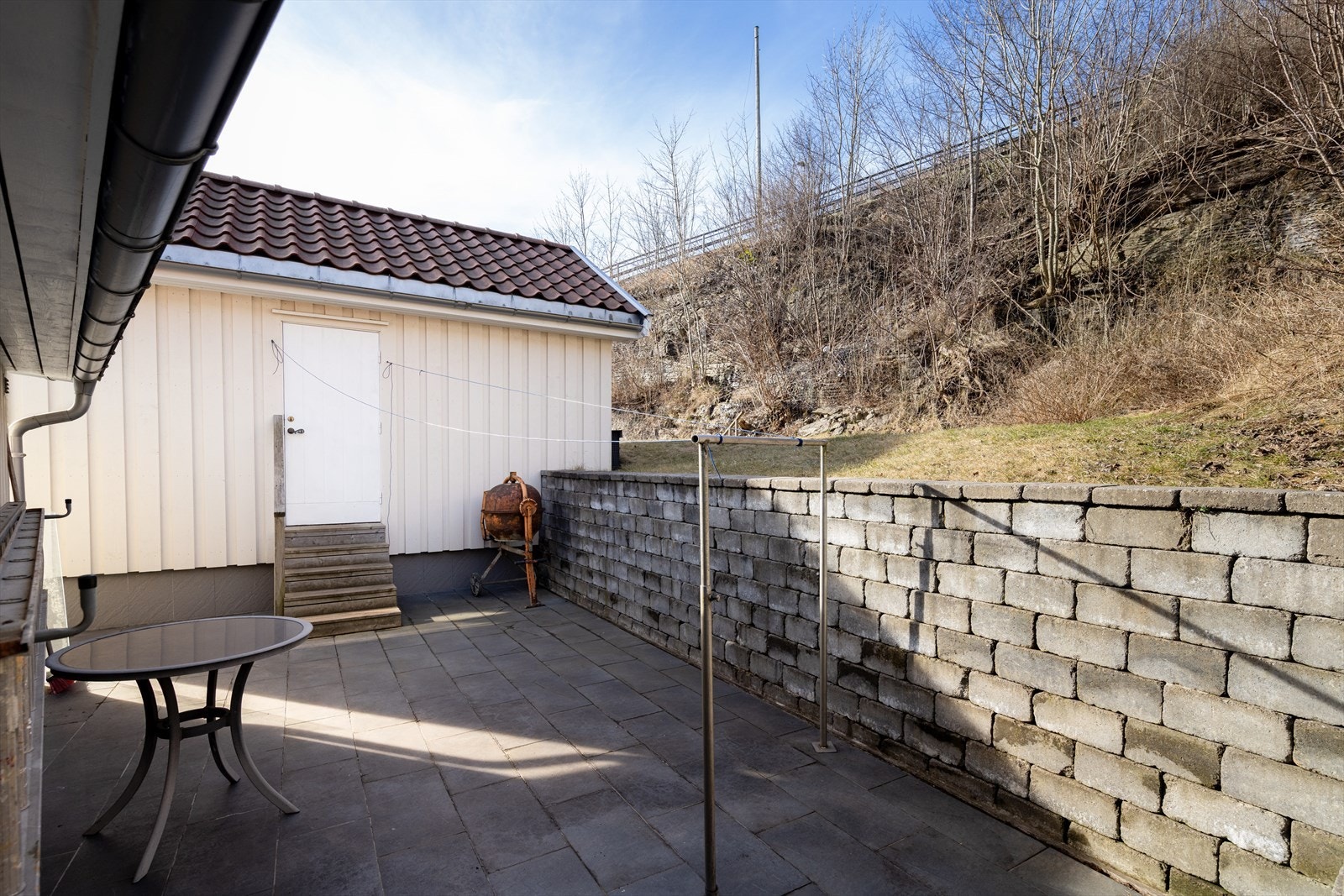 Tilbygget gang og nytt, frittstående uthus, samt støttemurer og uteplasser på eiendommen er oppført uten at dette er søkt om og uten at eventuell nødvendig godkjennelse er gitt av kommunen. Galleribilde