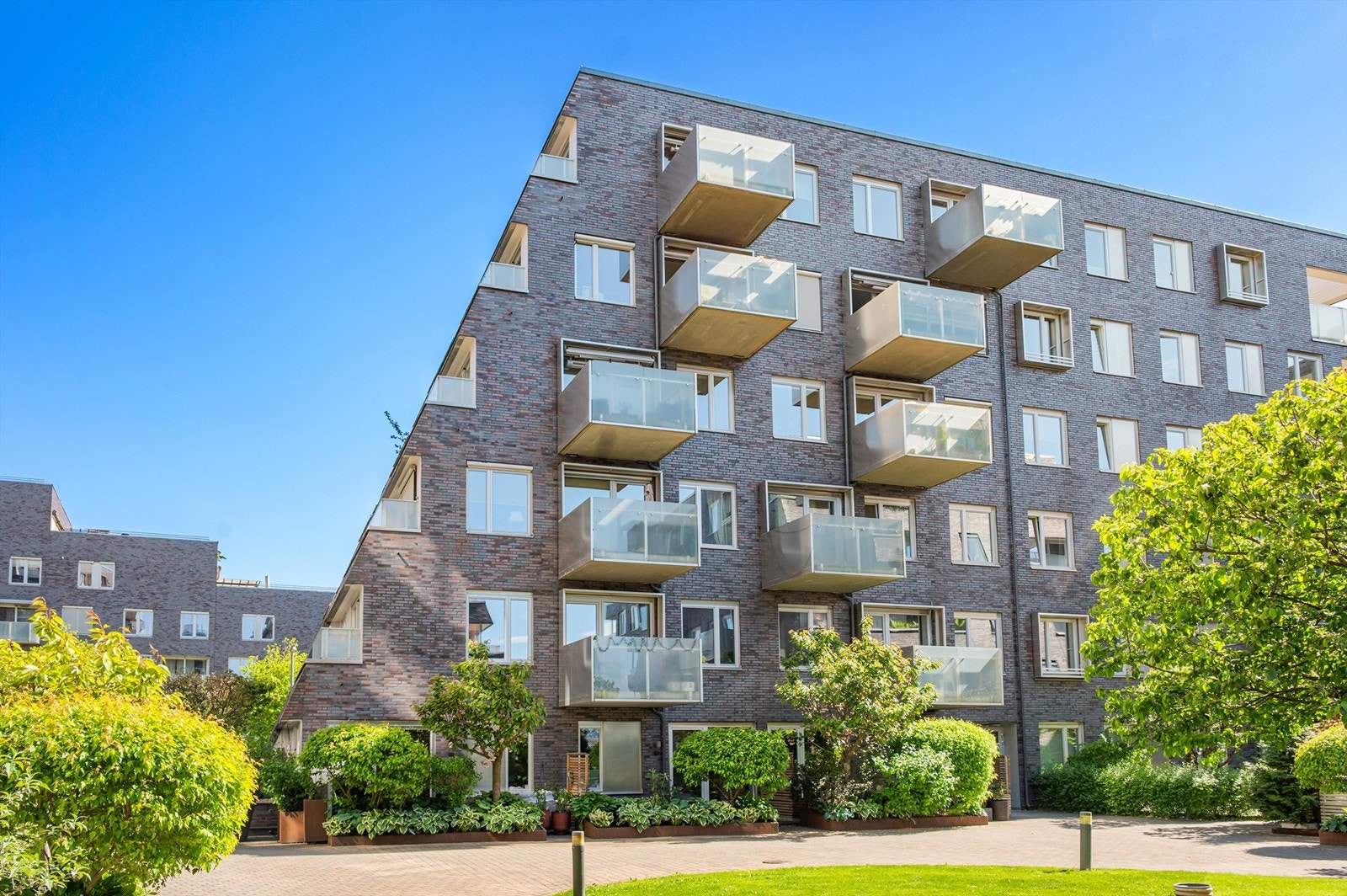 Fasade, leiligheten til venstre. Unik rekkehusfølelse ved direkte adgang til plen og sittegrupper i atriumet. Legg merke til at leiligheten oppleves usjenert. Galleribilde