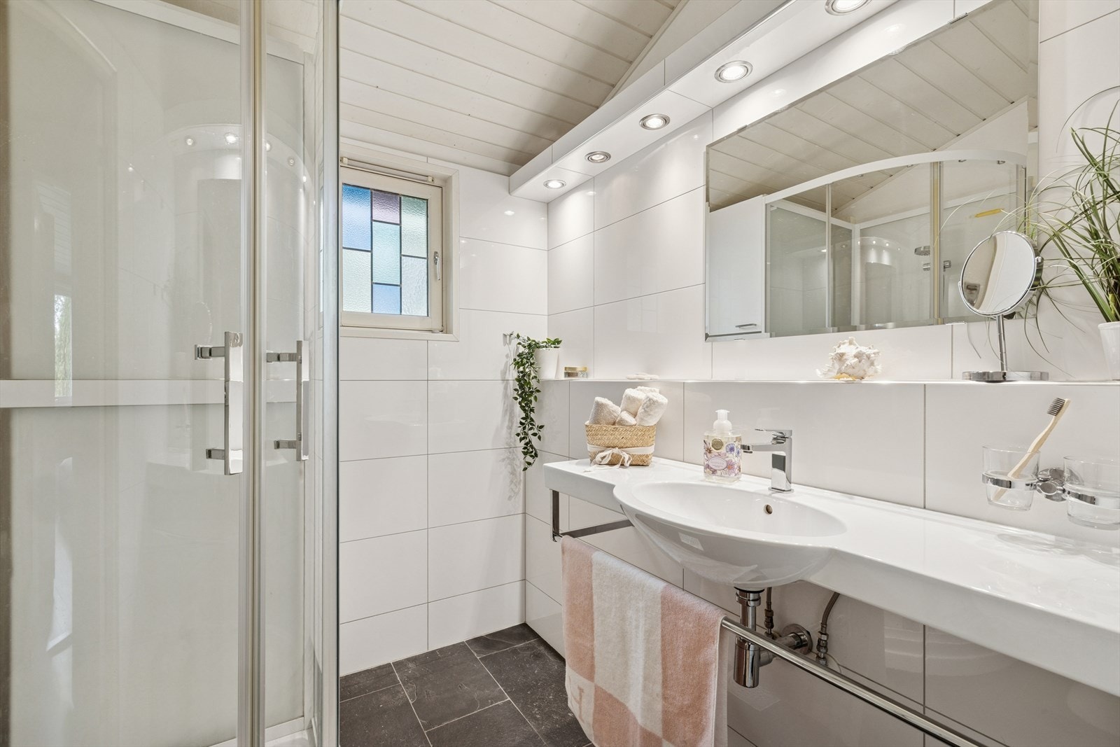 Alle boligens 3 baderom er tidløse, med lyse fliser og skifer på gulv. Galleribilde