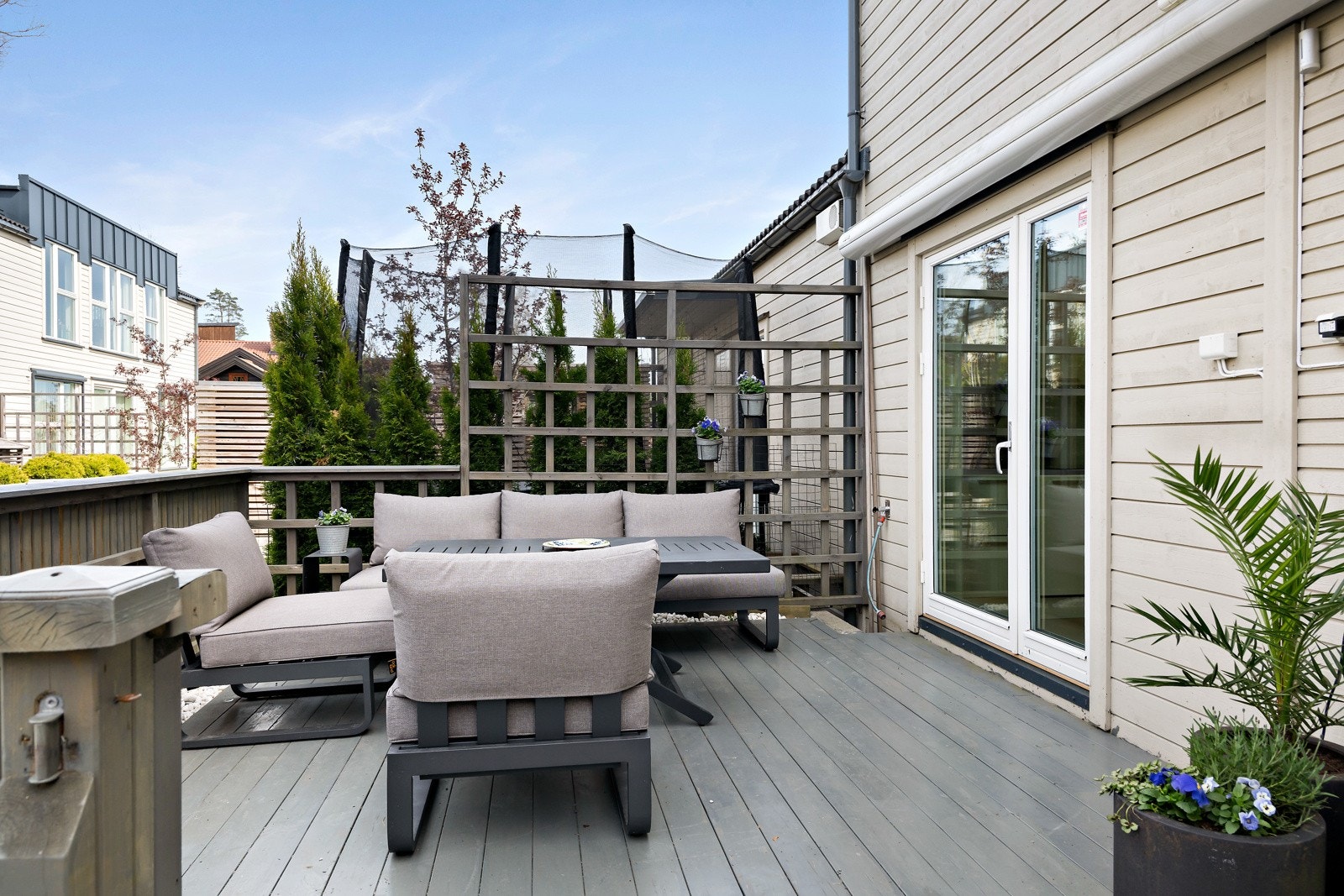 Fin terrasse utenfor kjøkkenet med god plass til møblement og grillen. Elektrisk markise som dekker hele sittegruppen Galleribilde