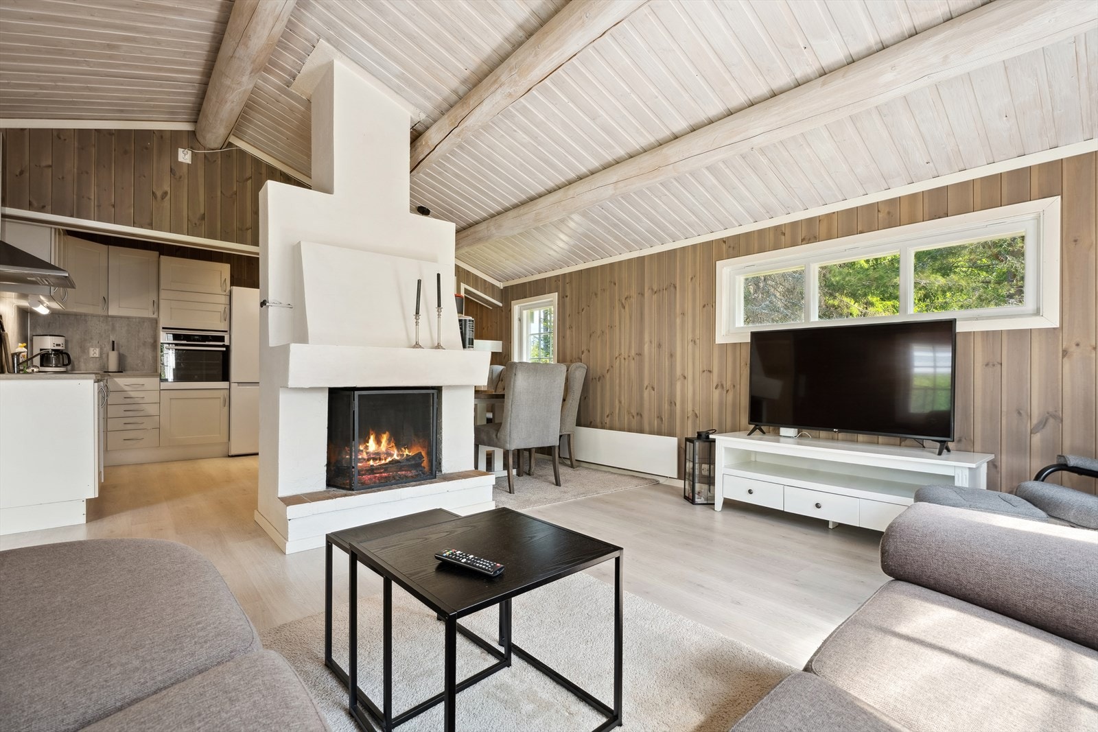 Stor peis midt i rommet skaper en lun og hyggelig stemning i stua. Galleribilde