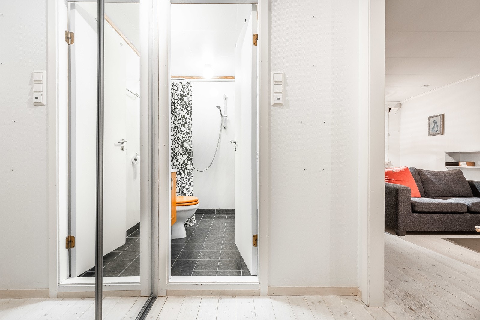 Gang med romslig skyvedørsgarderobe og speilfasade.