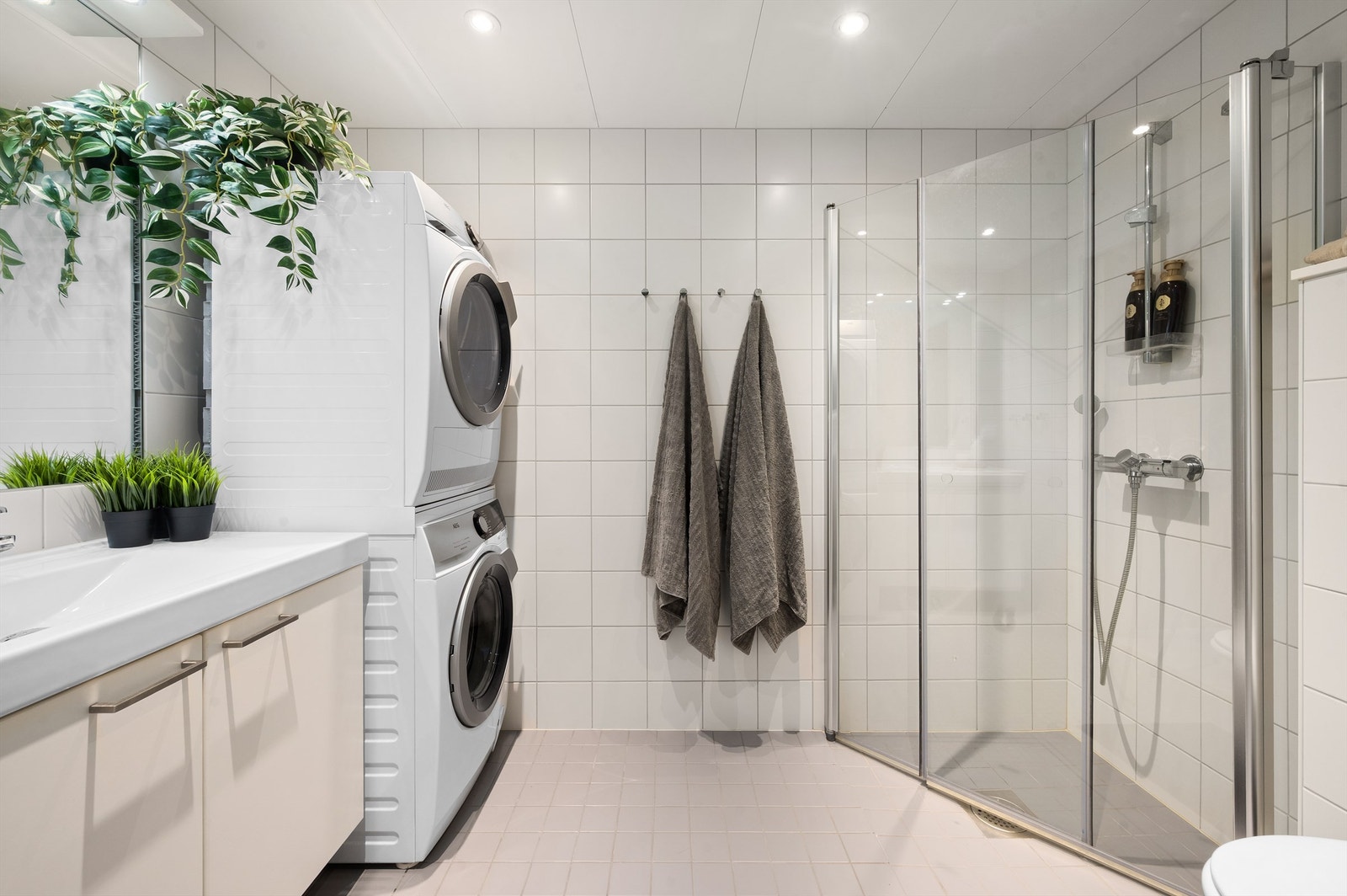 Badet er pent flislagt på gulv og vegger. Varme i gulvet sørger for en behagelig start på dagen. Galleribilde