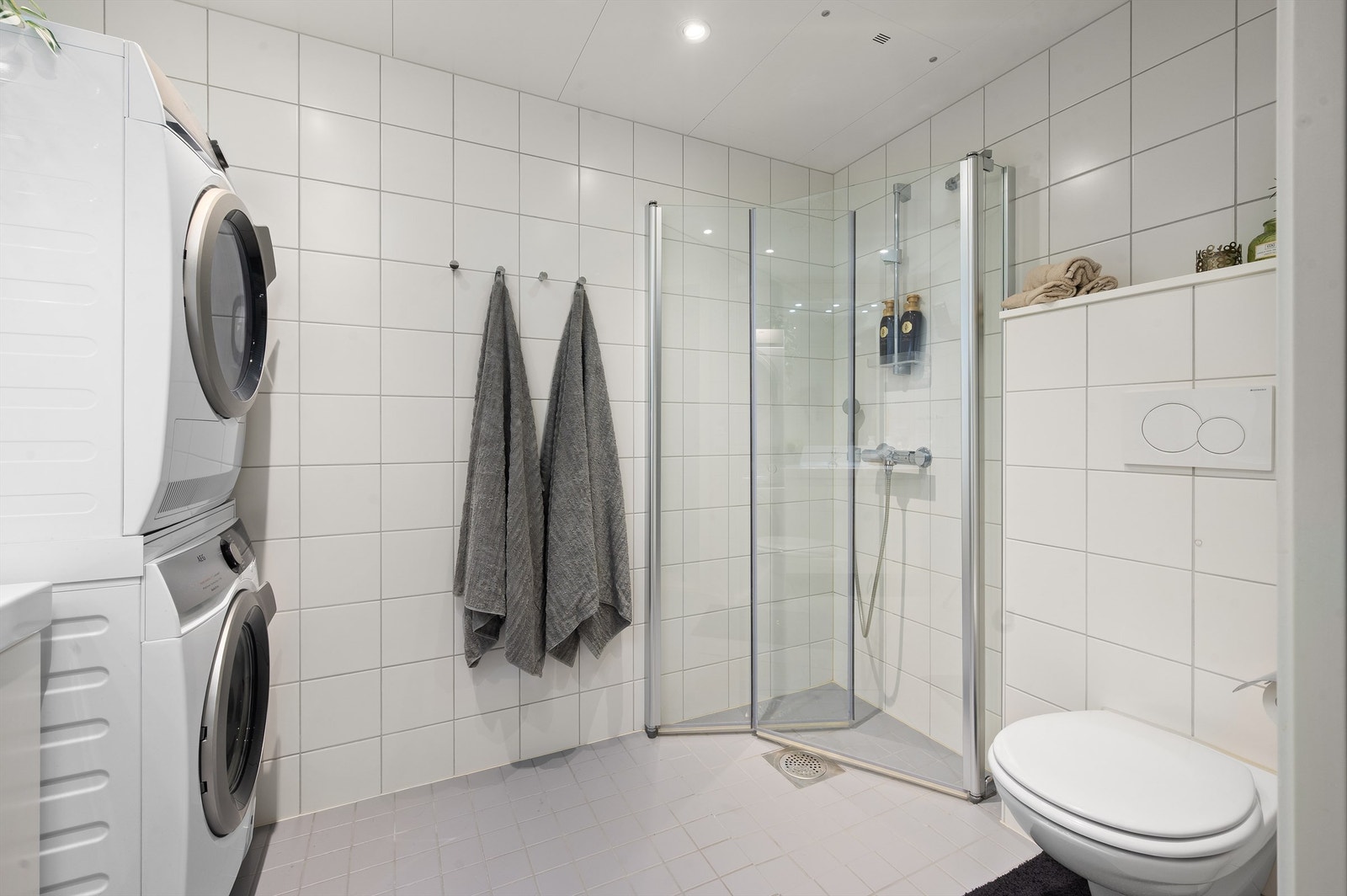 Videre har badet dusjhjørne med svingbare glassdører og vegghengt klosett. Det er mekanisk avtrekk. Galleribilde