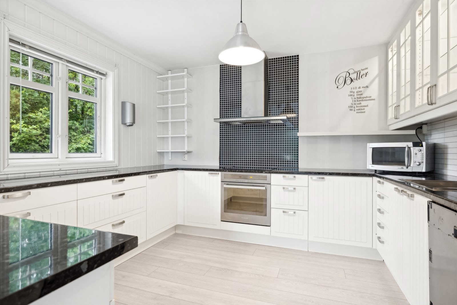 Romslig kjøkkeninnredning med medfølgende hvitevarer Galleribilde