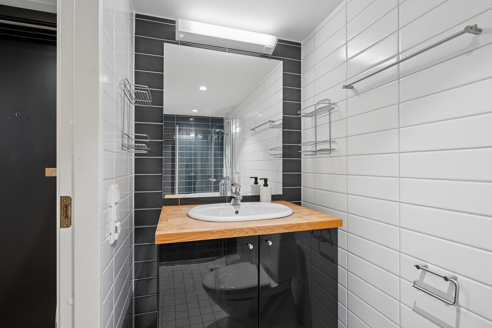 Følgelig har badet et heldekkende servant med underskap og overspeil med belysning. Galleribilde