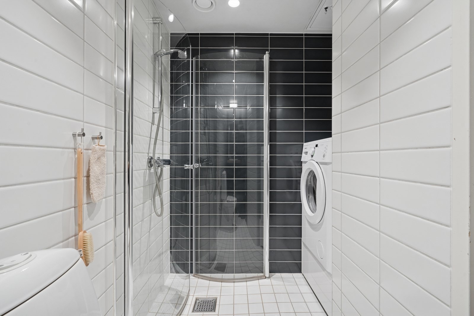 Badet har hjørnedusj med innfellbare dusjdører og et gulvfestet toalett. Galleribilde