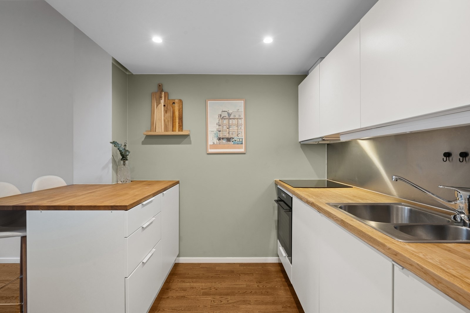 Kjøkkeninnredningen fra Kvik med slette lakkerte fronter og heltre eik benkeplate m/splashback over, 1 ½ oppvaskkum. Galleribilde