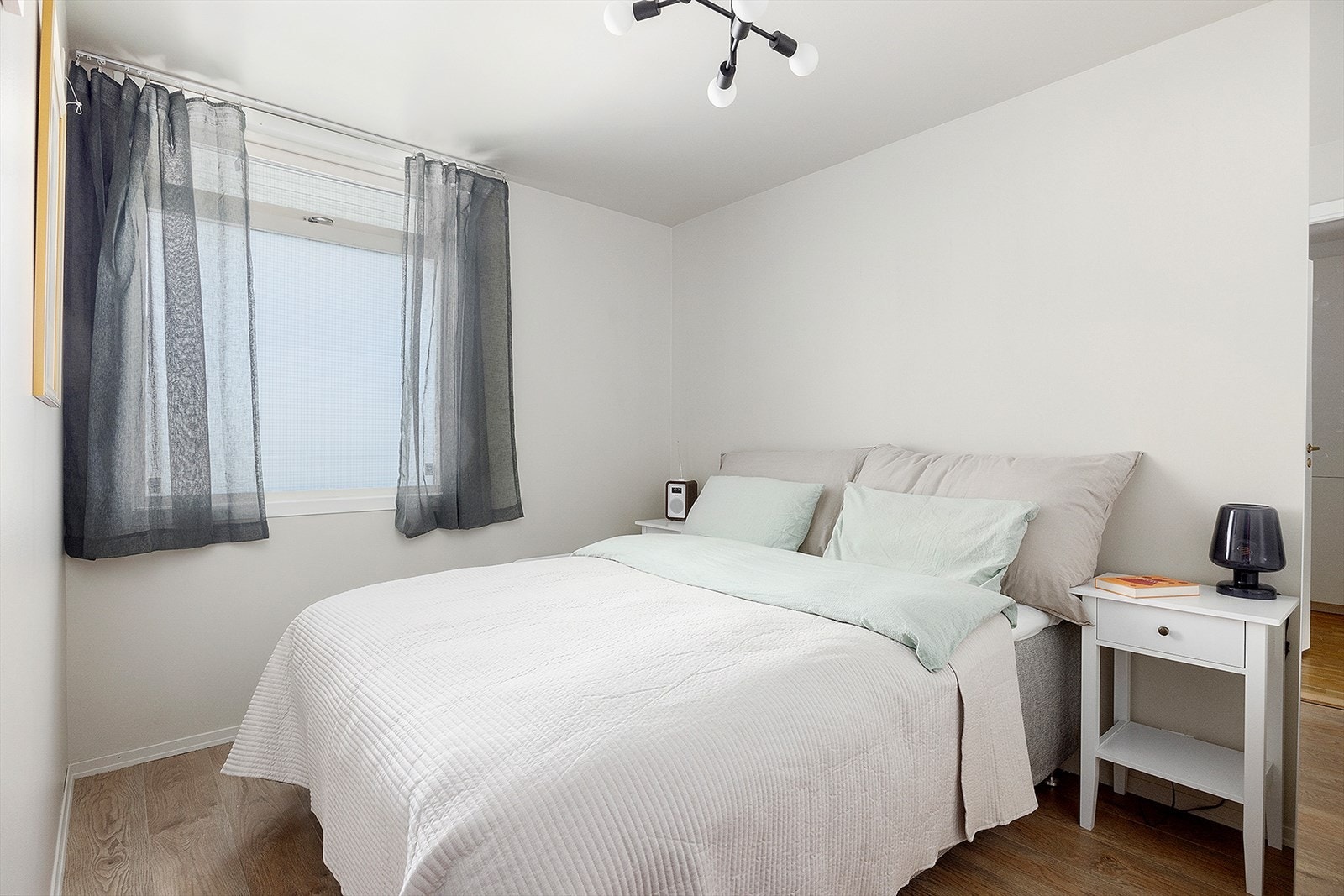 Romslig soverom med god plass til dobbeltseng, nattbord og garderobe Galleribilde