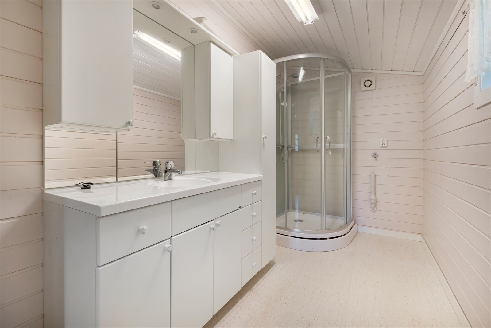 Flott bad med dusjkabinett, romslig innredning og opplegg til vaskemaskin Galleribilde