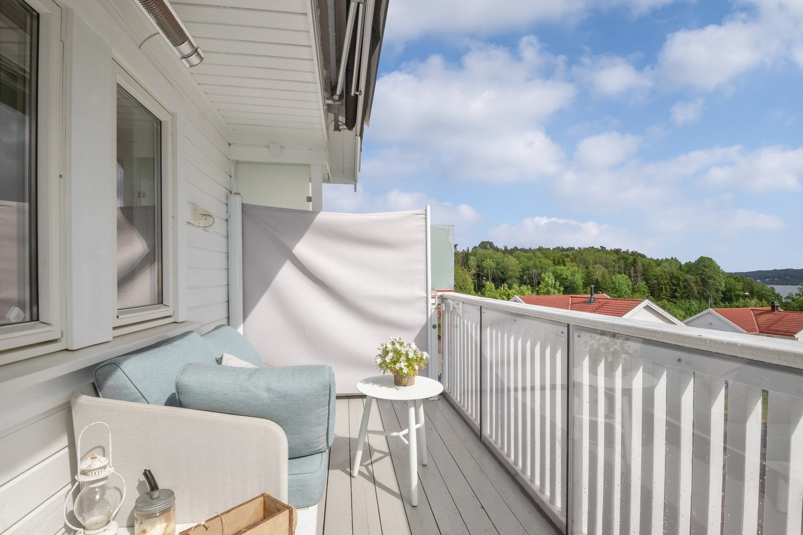 Mot naboen er det en uttrekkbar skjermvegg, og balkongen har et hvitmalt trerekkverk med plexiglass. Galleribilde