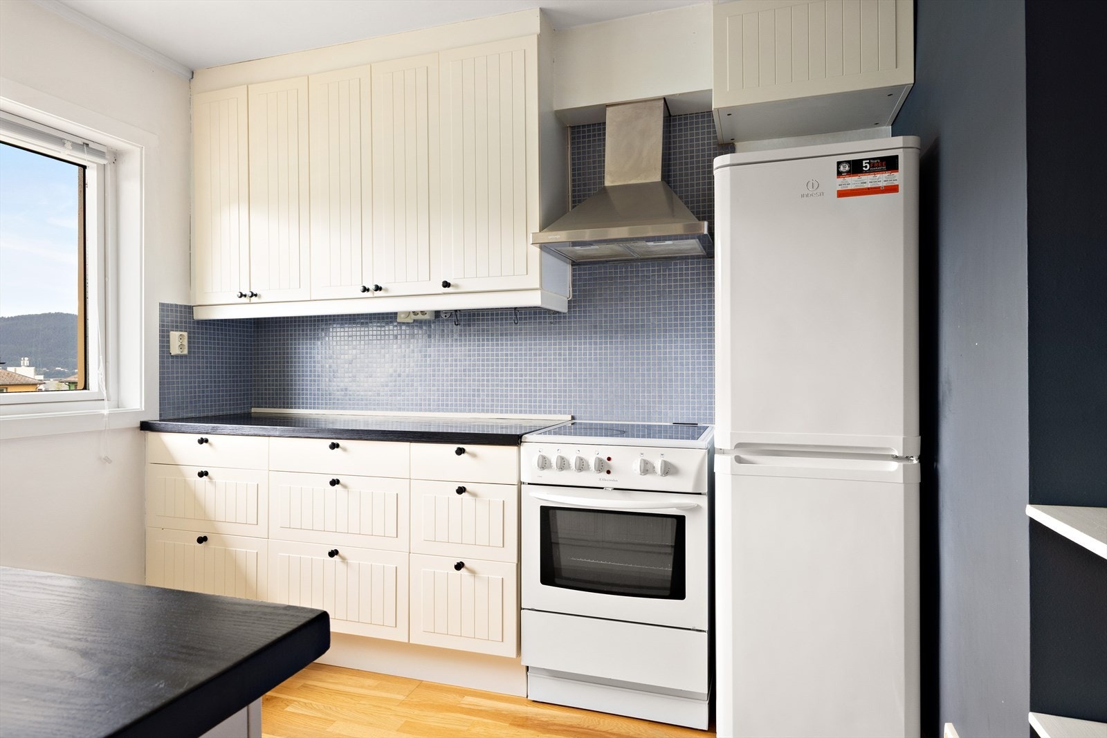 Kjøkkenet har profilerte fronter og en mørk laminert benkeplate. Galleribilde