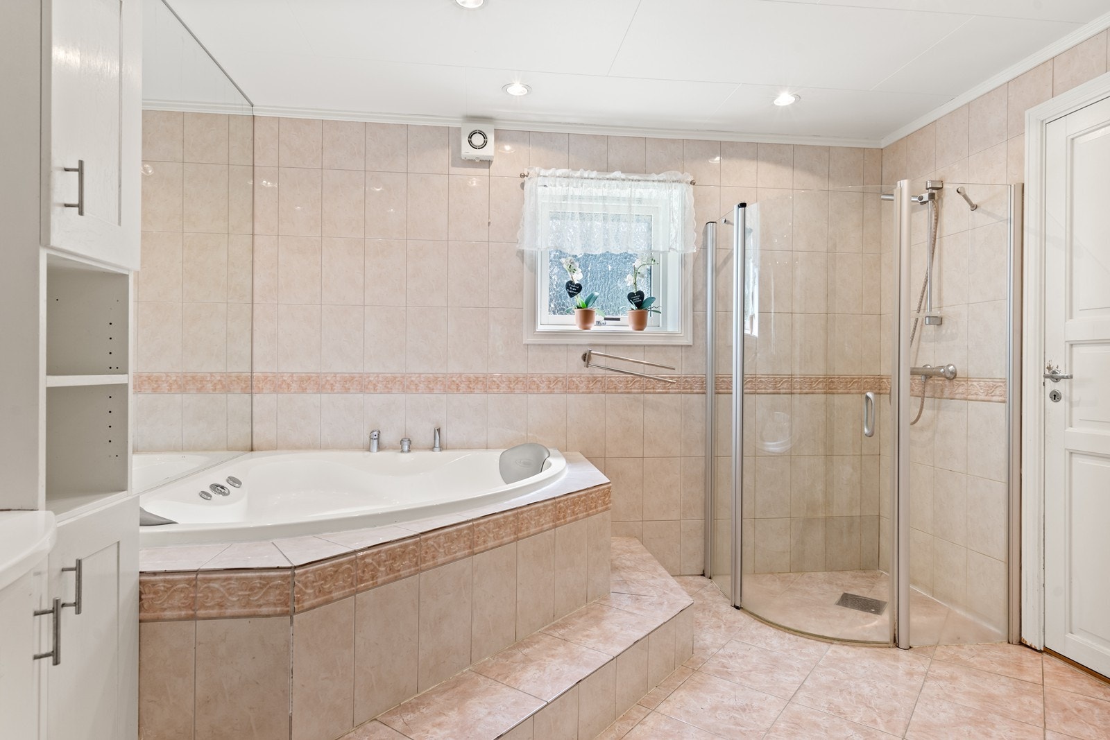 Stort flislagt bad med et deilig boblebadkar og dusj. Galleribilde