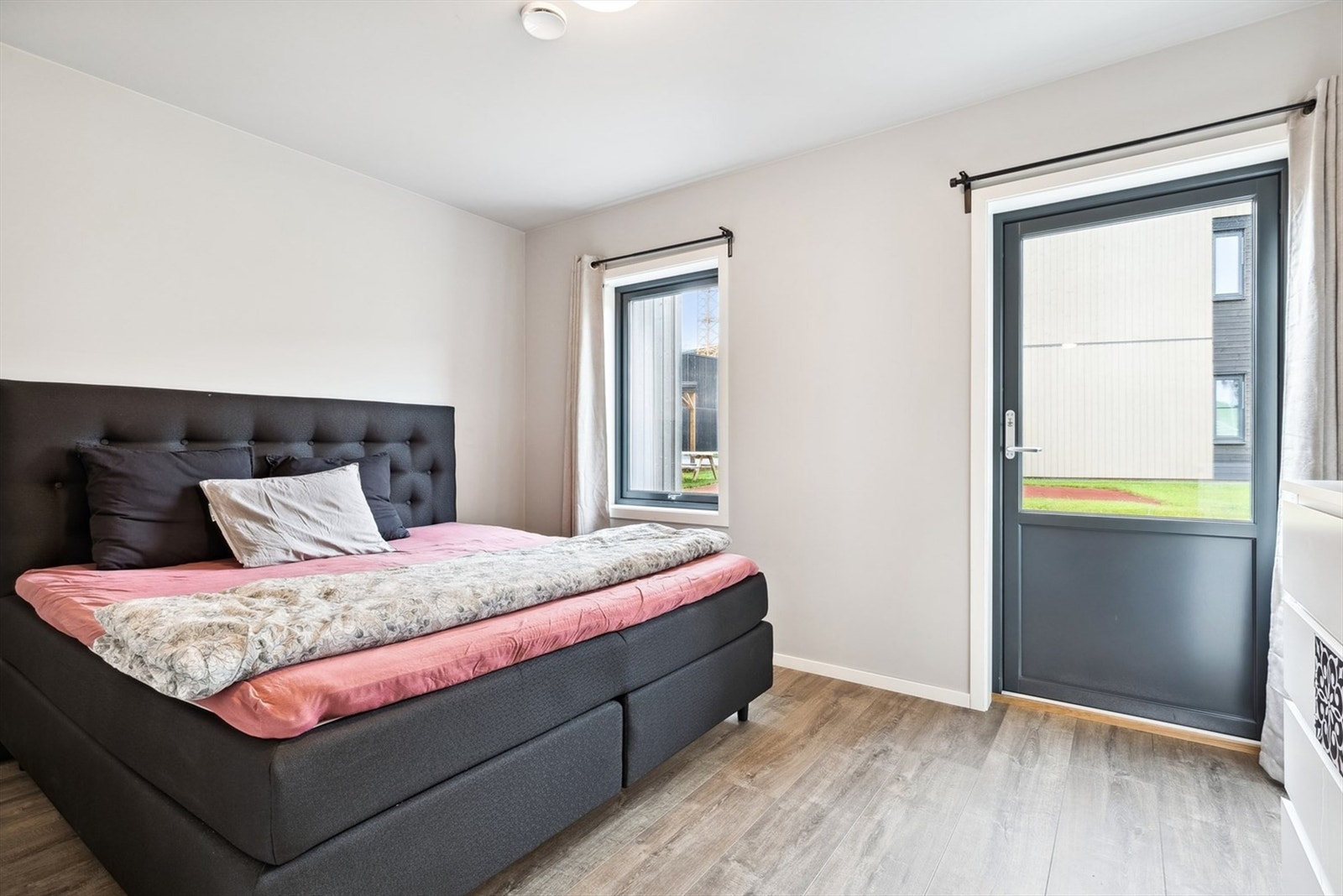 Det ene soverommet har direkte utgang til en markterrasse som gir enkel tilgang til uteområdene Galleribilde