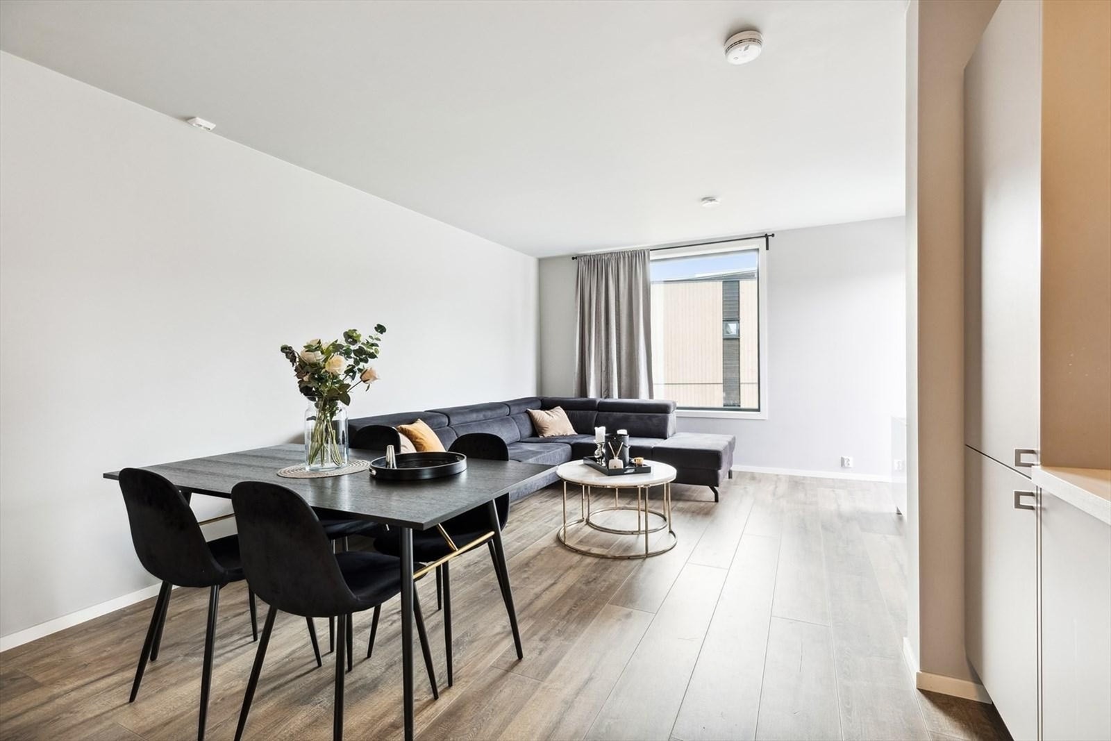 Romslig og lys stue med store vinduer som slipper inn naturlig lys Galleribilde