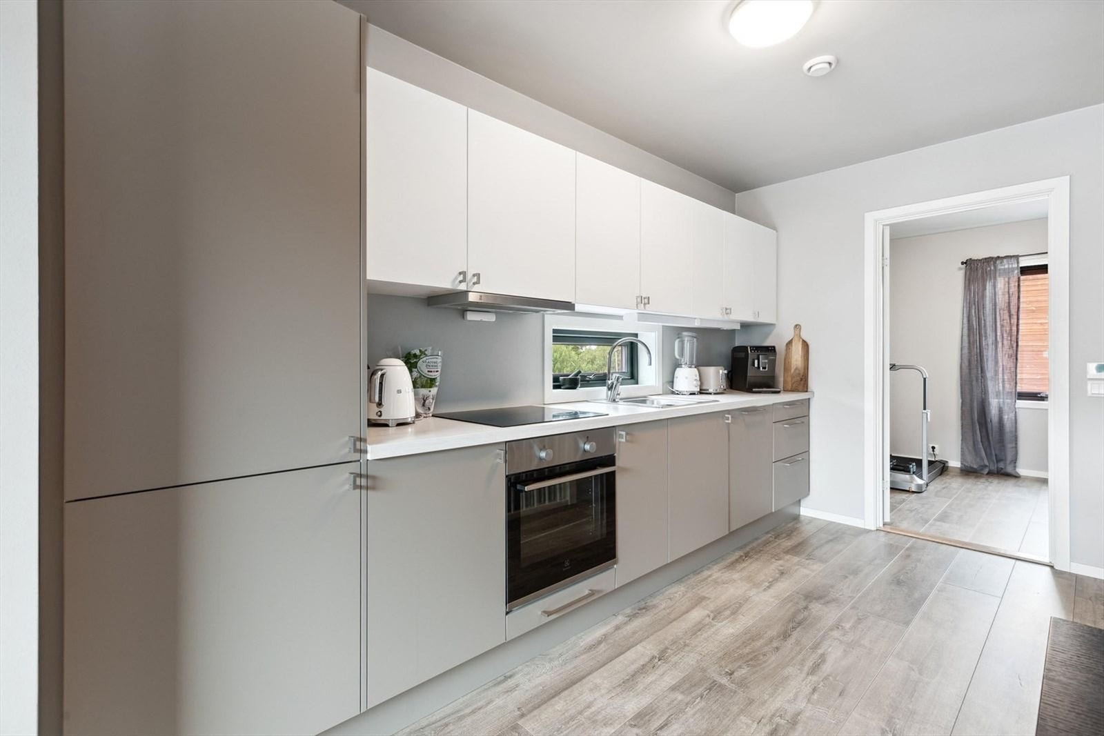 Benkeplaten i laminat gir god arbeidsplass, og den åpne løsningen mot stuen gjør kjøkkenet til et sosialt rom Galleribilde