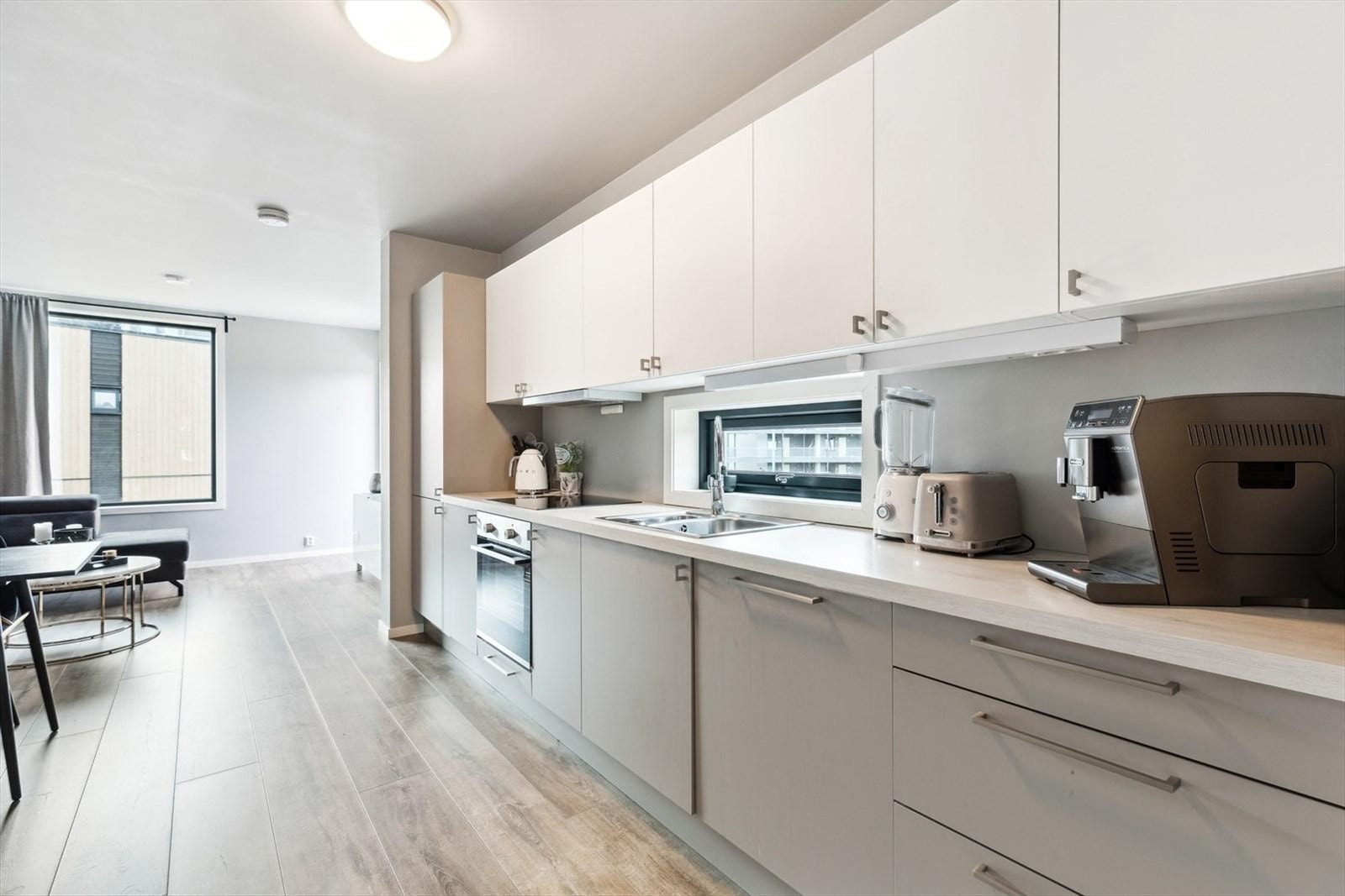 Moderne kjøkken fra Sigdal med hvitevarer som induksjonstopp, stekeovn, kjøl/frys og oppvaskmaskin Galleribilde