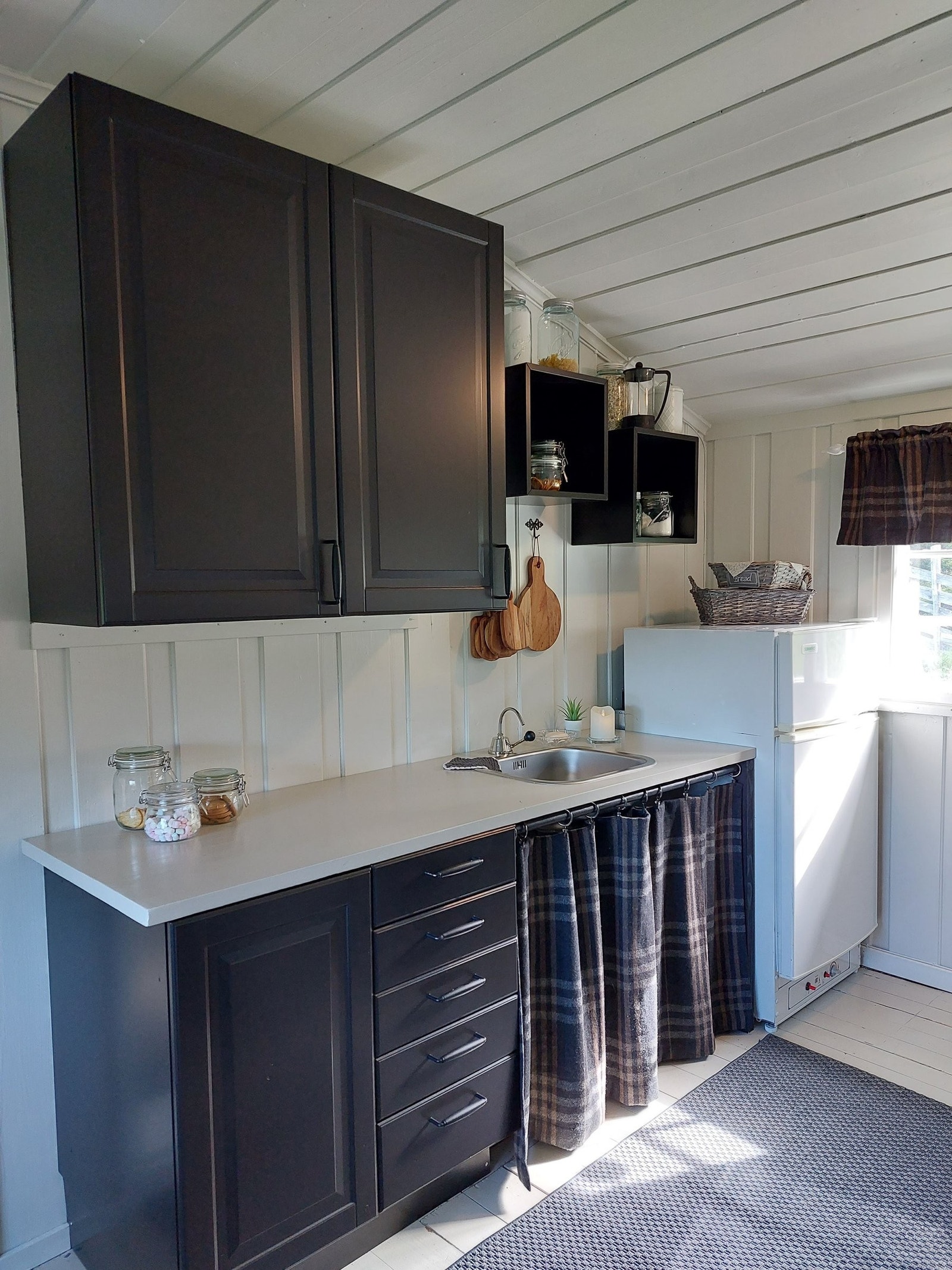 Praktisk kjøkken med god oppbevaring for vann under vask som gir "vann i krana". Galleribilde