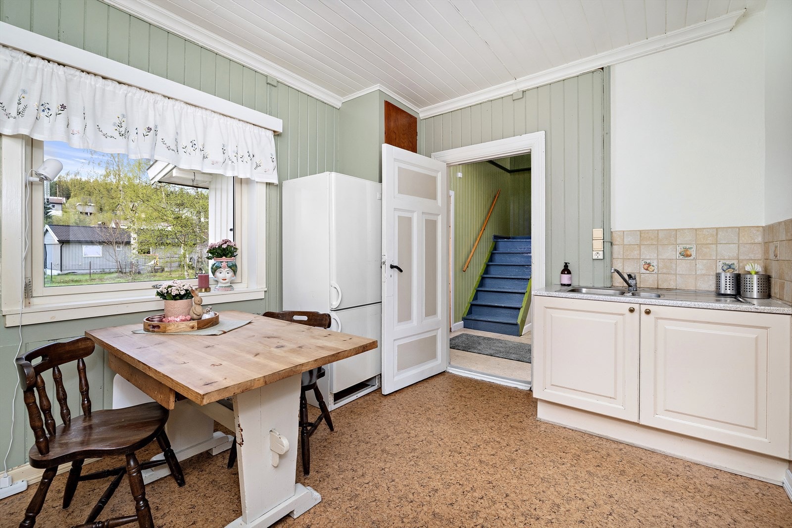 Innredningen har avsatt plass til kjøleskap og komfyr, og det er plass for et lite kjøkkenbord ved vinduet. Galleribilde