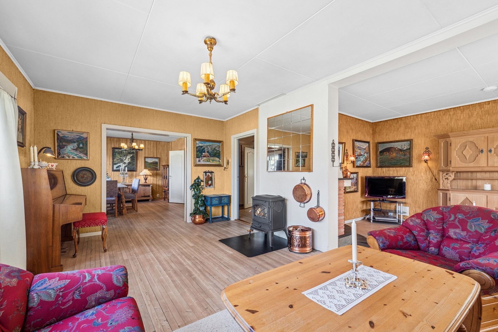 Stuen har god plass til sofagruppe med TV-løsning, godstol og et spisebord mot kjøkkenet. Galleribilde