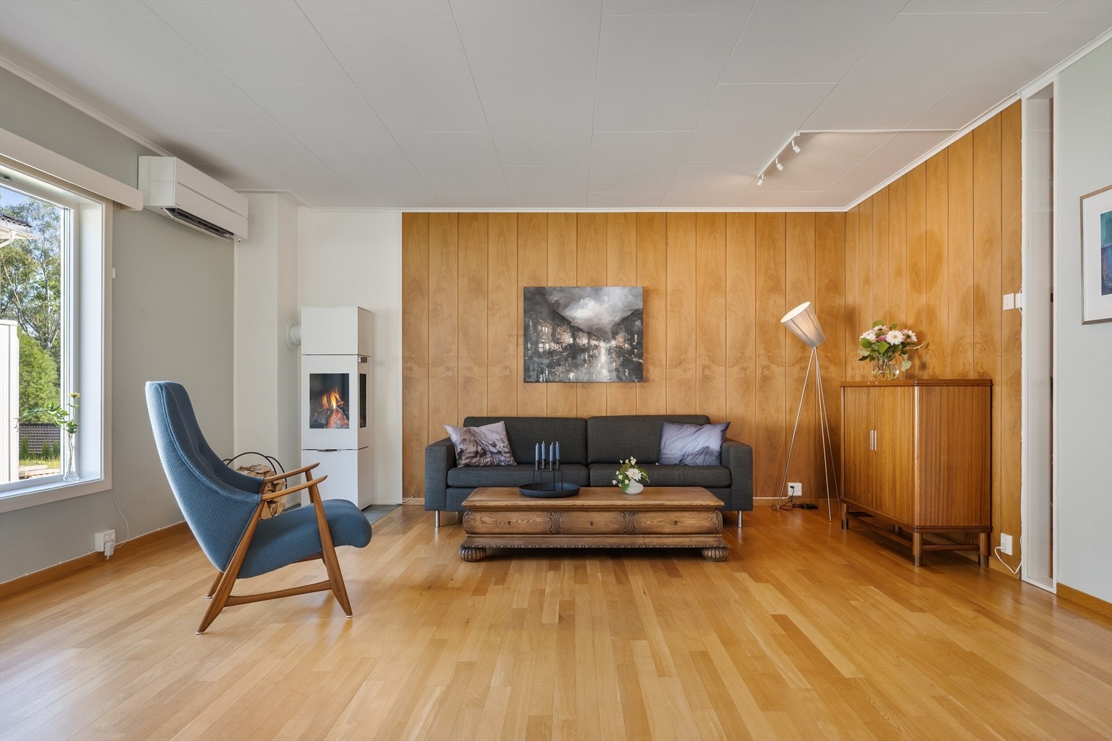 Stue med peisovn fra 2019 og heltre stavparkett og varmepumpe. Galleribilde