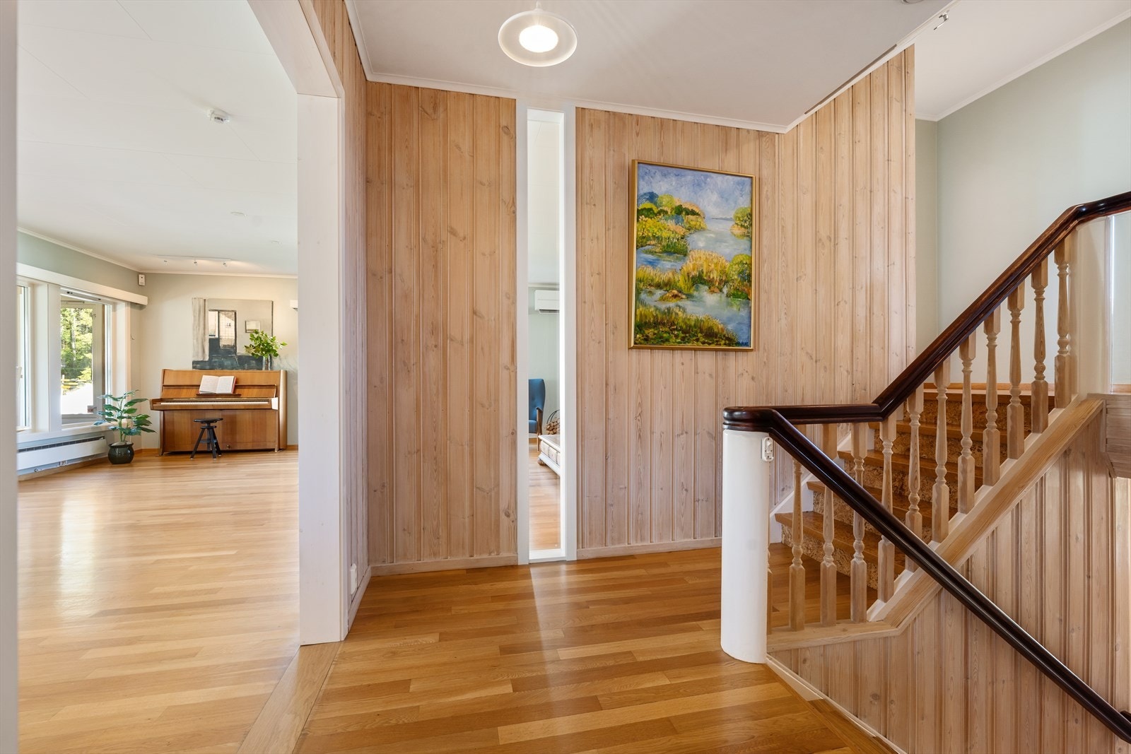 Innbydende hall med lakkert tretrapp som binder etasjene sammen. Galleribilde