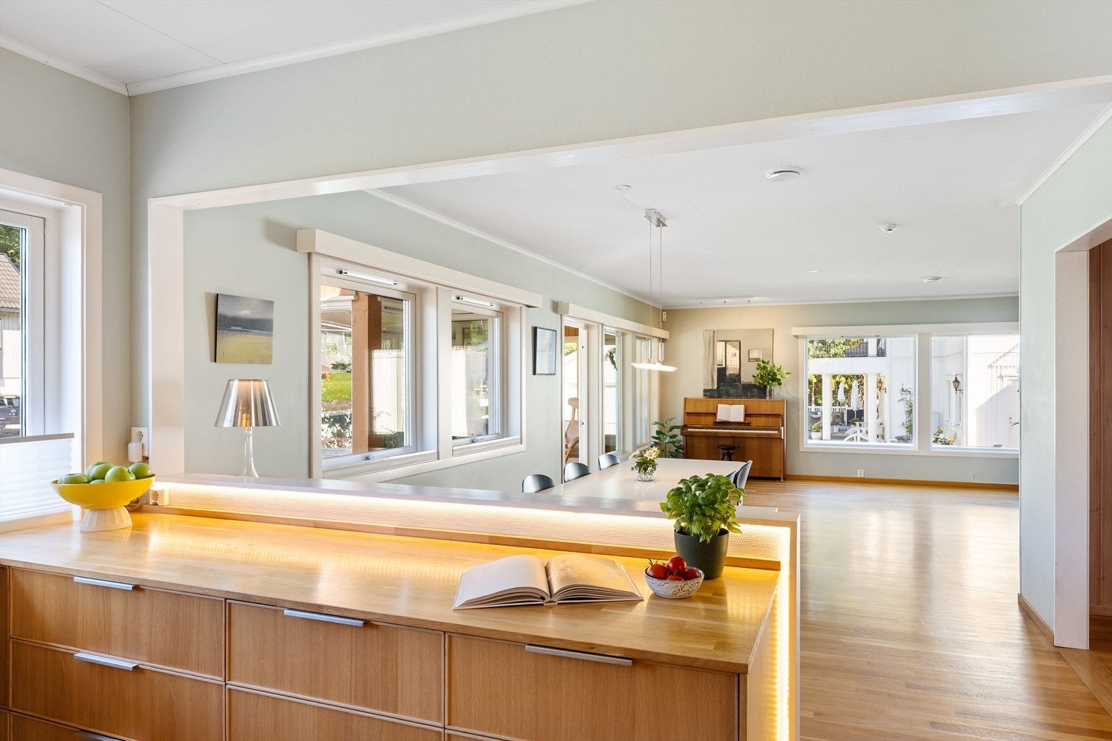 Åpen løsning mellom kjøkken og stue med mye naturlig lys og store flater. Galleribilde