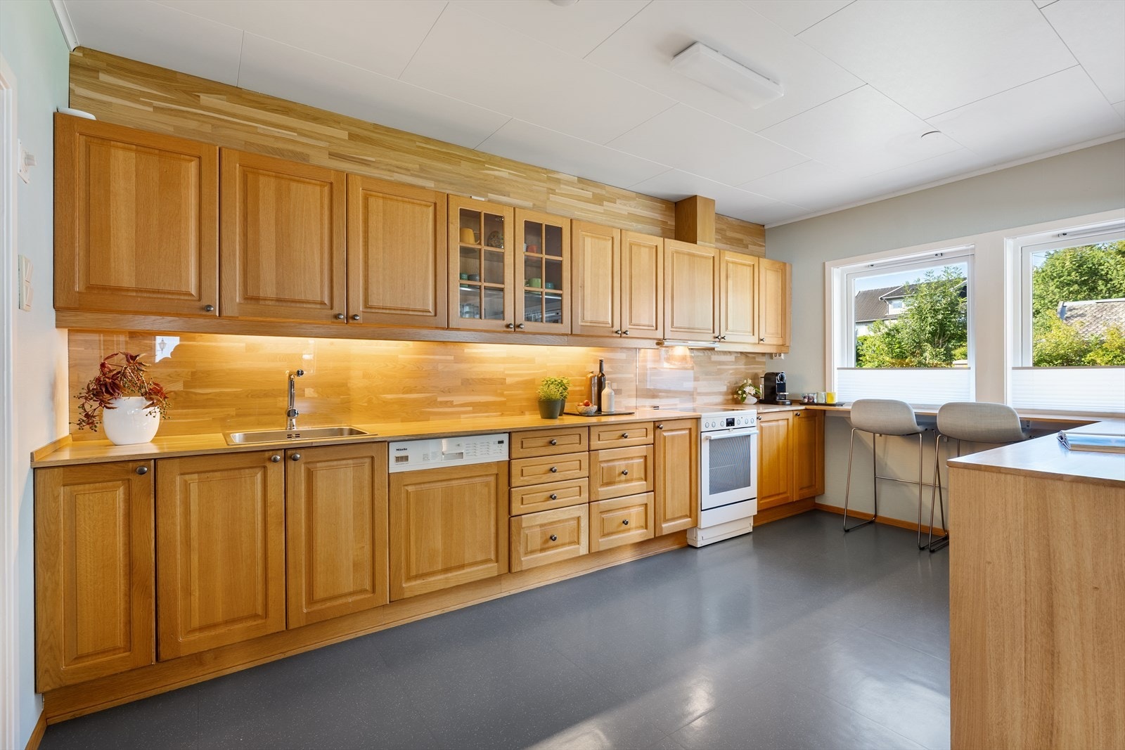 Kjøkken med integrerte hvitevarer og rikelig med arbeids- og oppbevaringsplass. samt at kjøkkenet har to benkekjøleskuffer fra Liebherr. Galleribilde