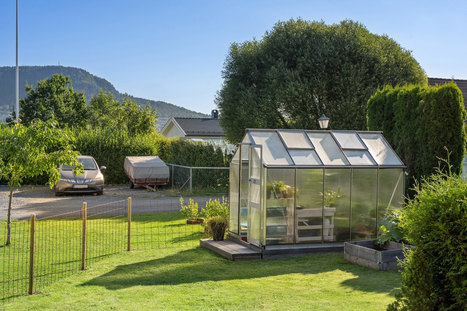 Velstelt hage med drivhus gir gode muligheter for dyrking av egne grønnsaker og urter. Galleribilde