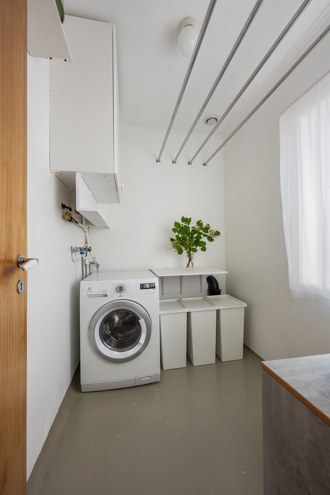 Eget vaskerom med opplegg for vaskemaskin på innsiden av kjøkkenet. Galleribilde