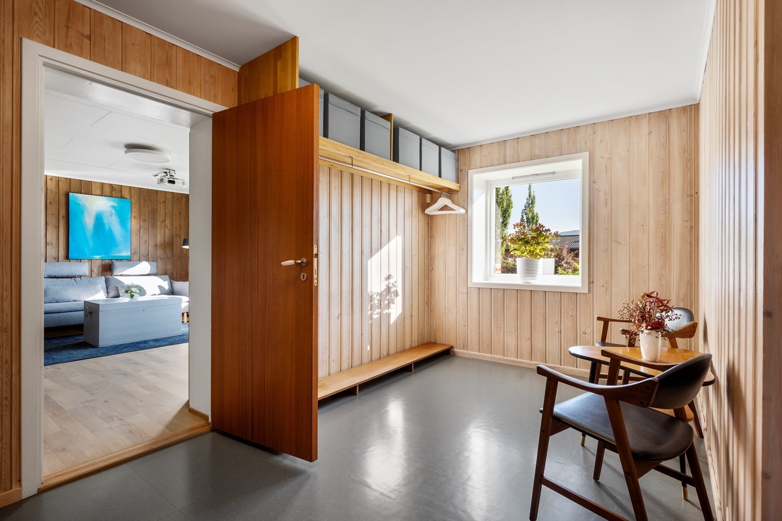 Lys gang med sitteplass og garderobeløsning, som gir praktisk flyt mellom rommene i underetasjen. Galleribilde