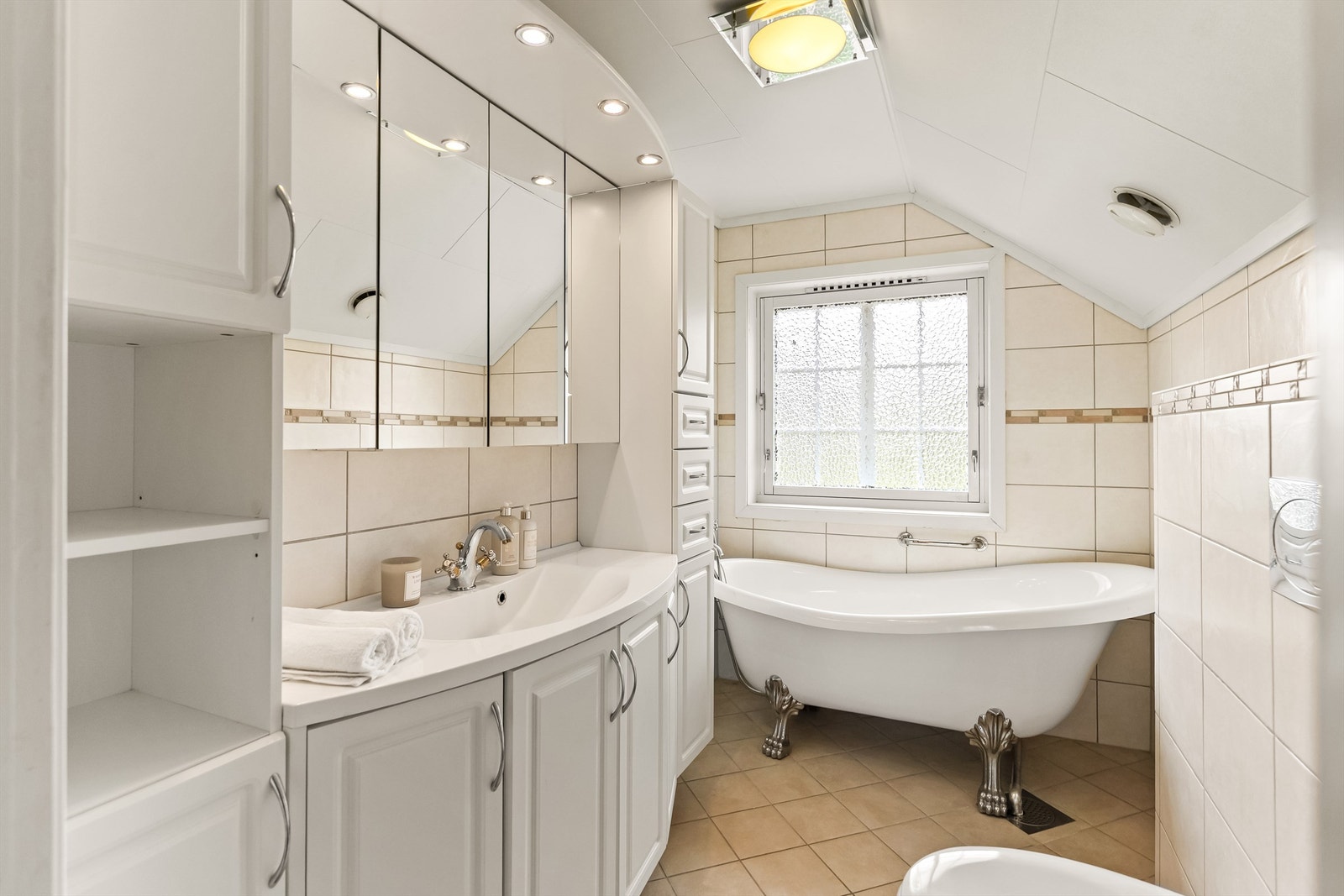 Praktisk bad i 2. etasje, flislagt med gulvvarme og god skapplass, som gir både komfort og funksjonalitet. Galleribilde