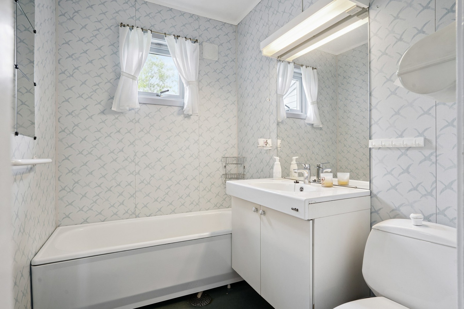 Badet er utstyrt med en moderne innredning. Her er det nedfelt servant og speil med belysning. Galleribilde