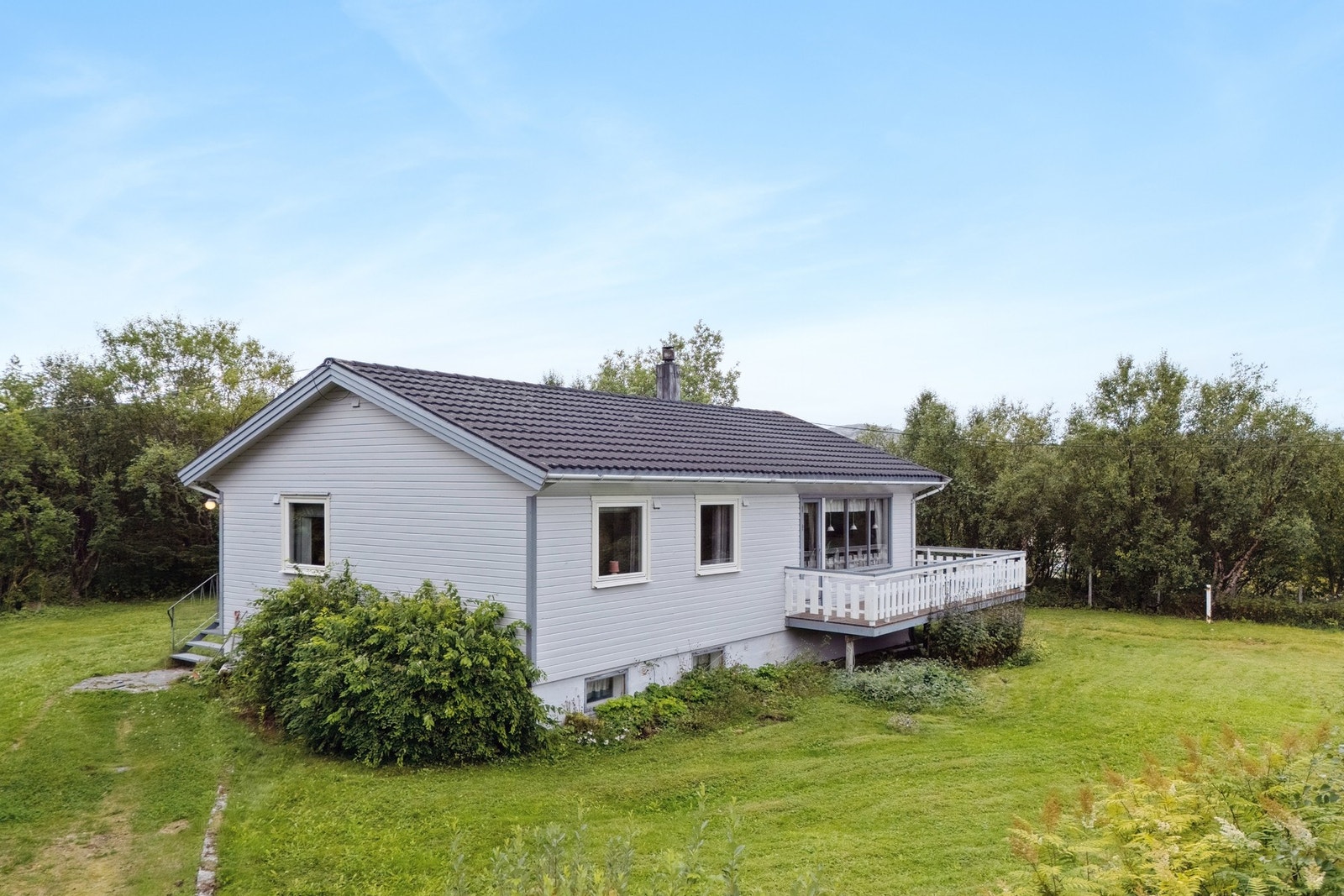 Tomten er pent opparbeidet med plen og beplantning. Galleribilde