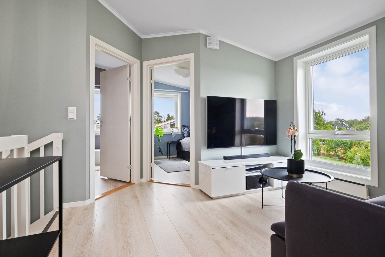 Loftstuen er lys og innbydende med enstavs laminatgulv og grønnmalte vegger, med utsikt over jordene. Galleribilde