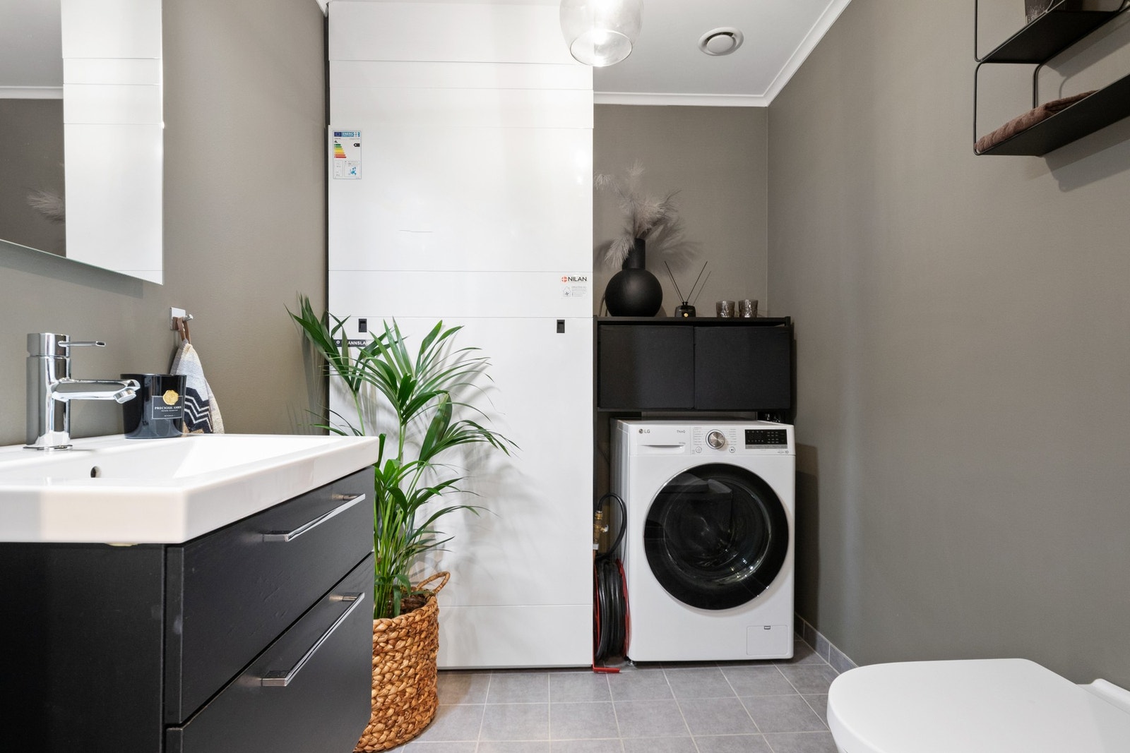 Toalettrom i første etasje. Toalettrommet har vegghengt toalett, sort skuffeinnredning med servant og nisje med opplegg for vaskemaskin. Galleribilde