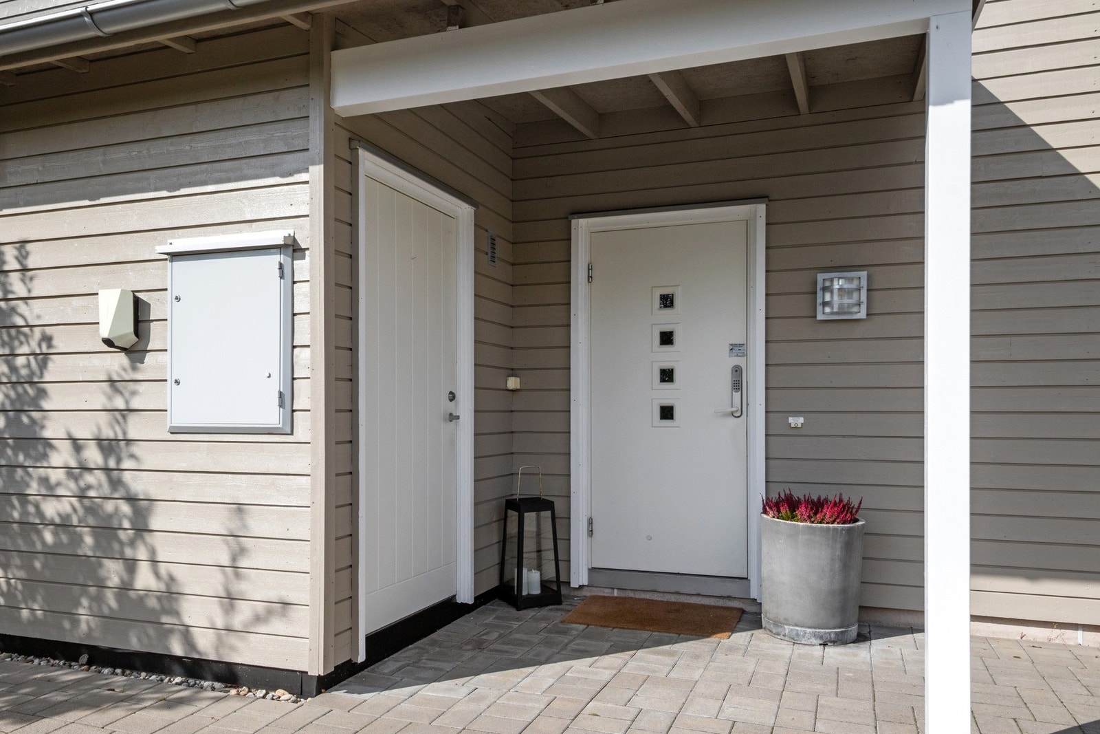 Boligen har et overbygd inngangsparti med dør både til entreen og en utebod på ca. 5 kvm. Galleribilde
