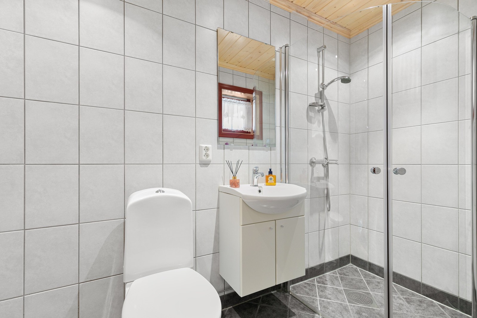 Hyttas andre bad har servantinnredning, gulvmontert toalett og dusjhjørne med innfellbare dusjvegger. Galleribilde