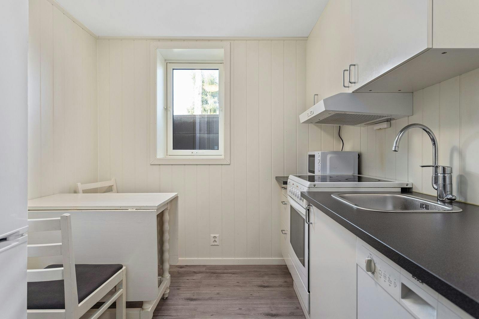 Videre er kjøkkenet også utstyrt med et lite spisebord. Galleribilde