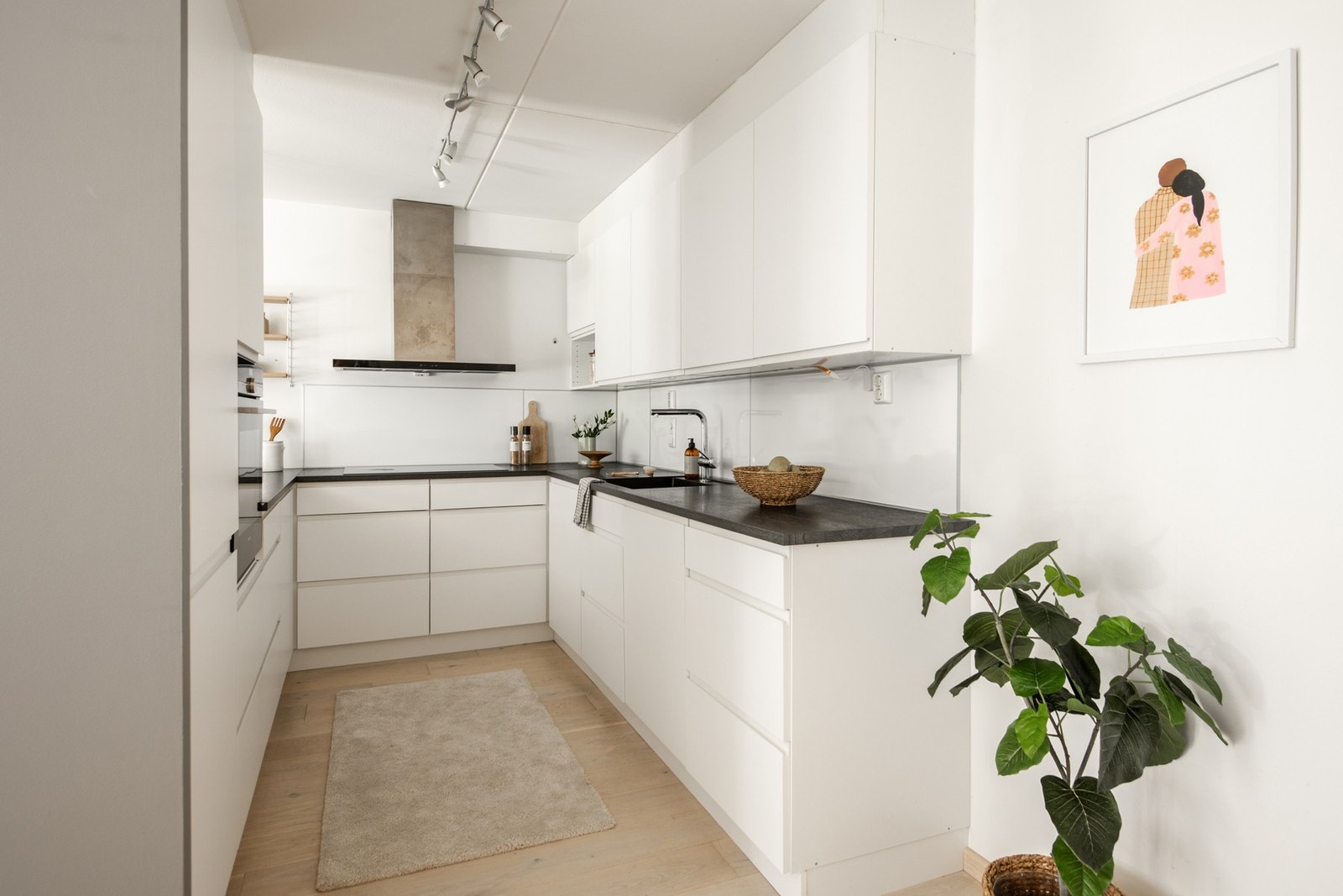 Glatte fronter, laminat benkeplate og belysning under overskap gir en moderne look. Galleribilde