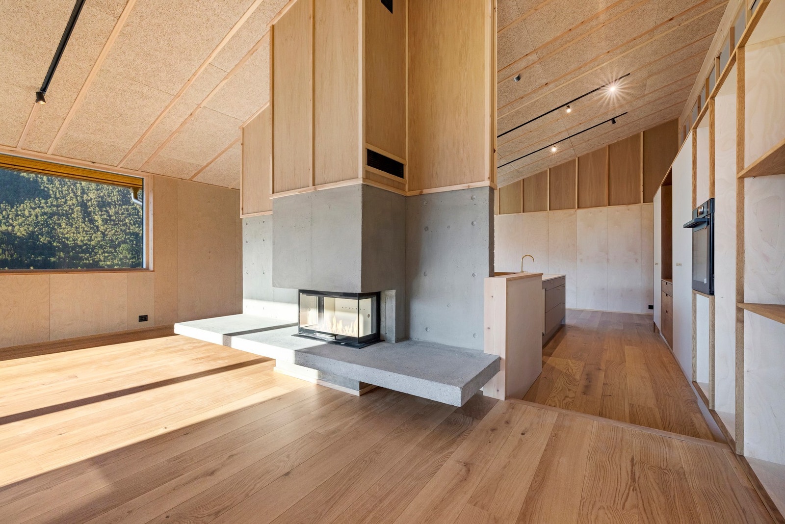 Stue og kjøkken i åpen løsning med peisen som en "romdeler". Det er vannbåren varme i alle gulv Galleribilde