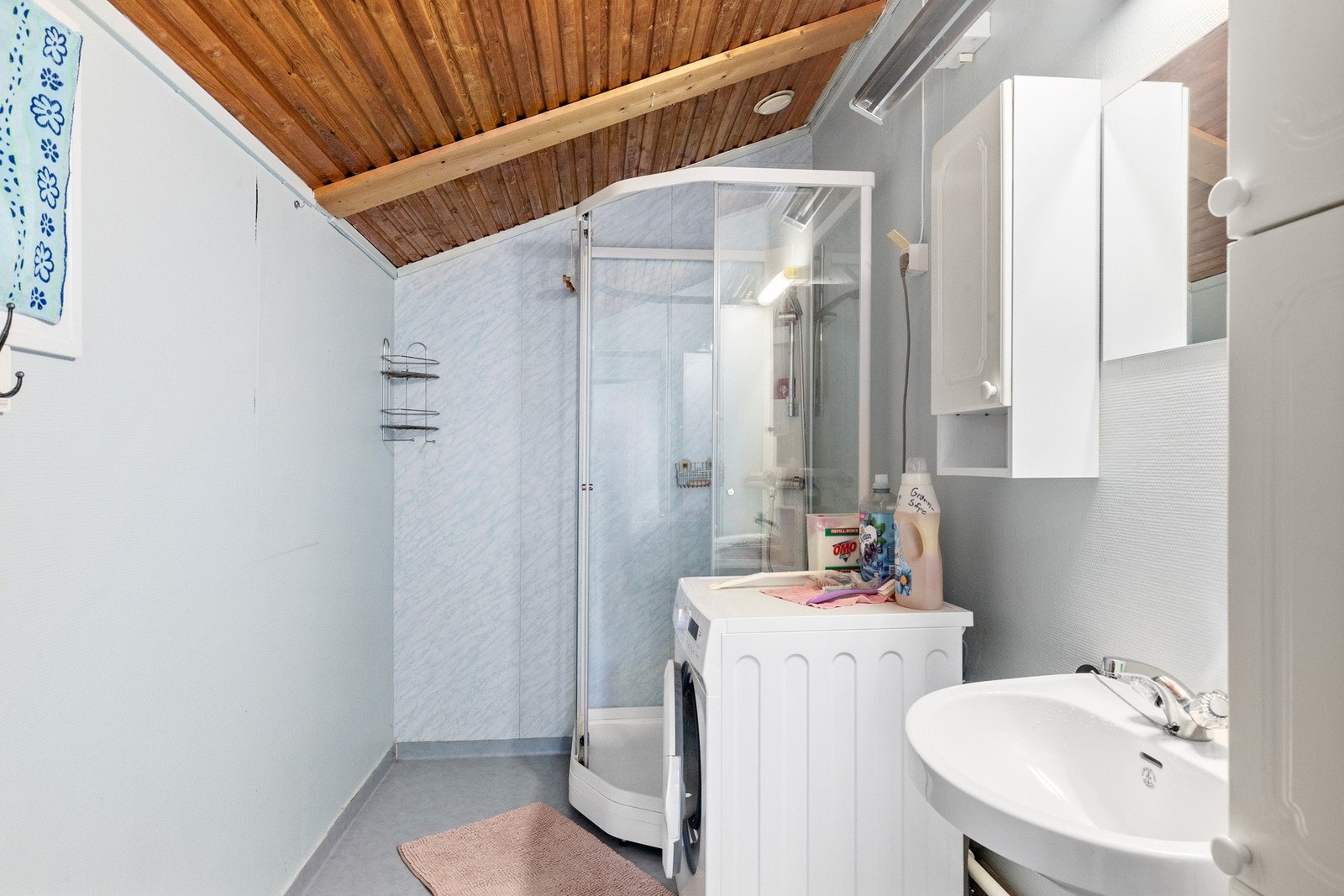 Baderom utstyrt med Utstyrt med dusjkabinett, servant, opplegg for vaskemaskin og naturlig avtrekk. Galleribilde