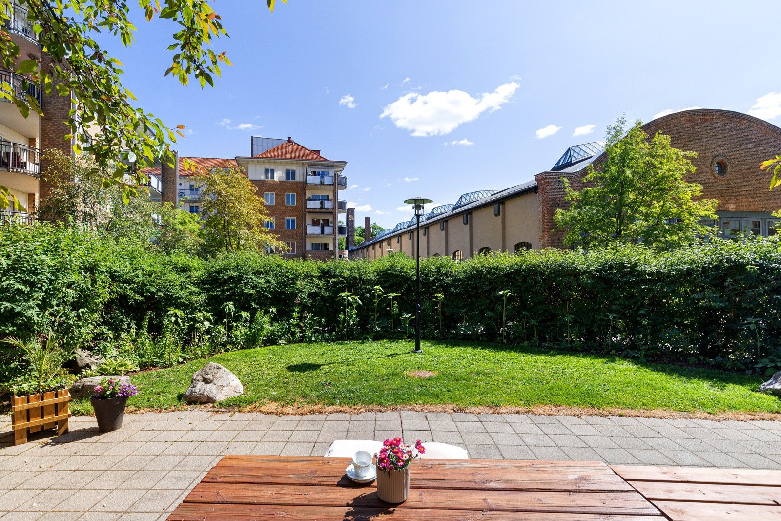 Pent felles gårdsrom som er opparbeidet med plen, hekk og bed. Galleribilde