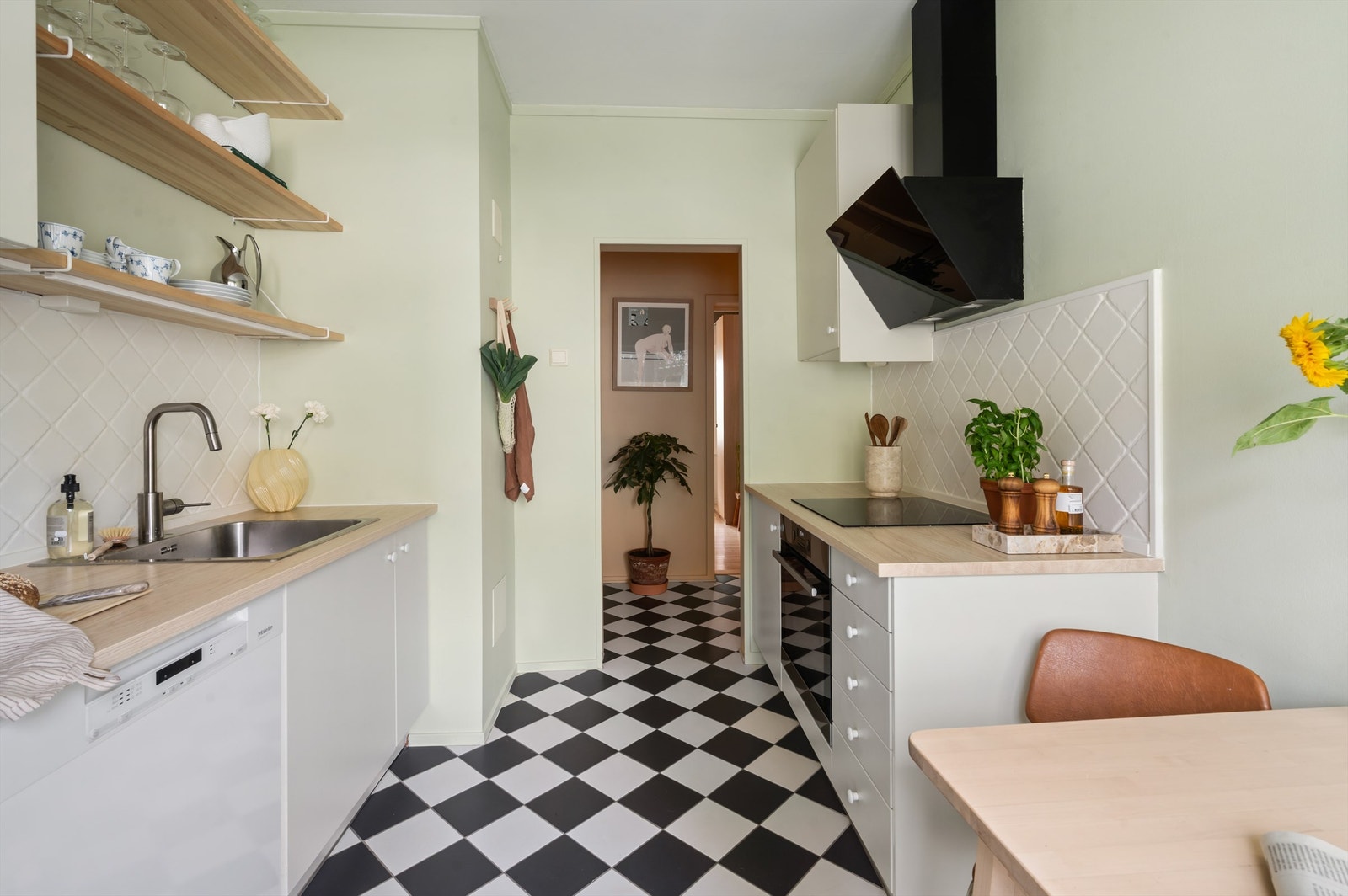 Kjøkkeninnredningen er av glatte fronter og benkeplate i laminat med nedfelt vaskekum. Induksjonstopp og stekeovn er sømløst integrert i innredningen. Det er opplegg for oppvaskmaskin. Galleribilde