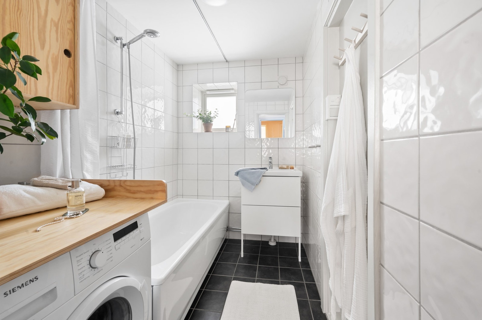 Badet er pent flislagt på gulv og vegger. Varme i gulvet sørger for en behagelig start på dagen. Baderomsinnredningen består av servantskap med servant. Galleribilde