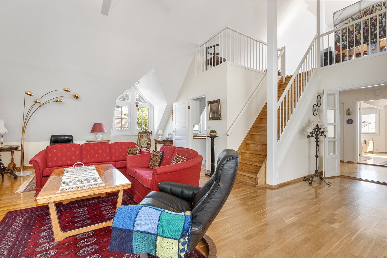 Stue med trapp opp til hems og terrasser. Galleribilde